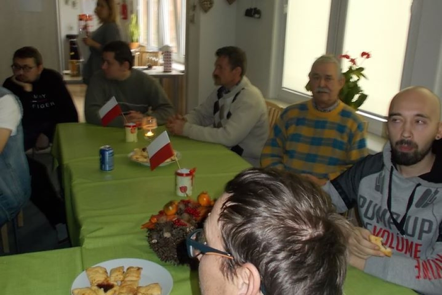 Uczestnicy siedzący przy stole z poczęstunkiem