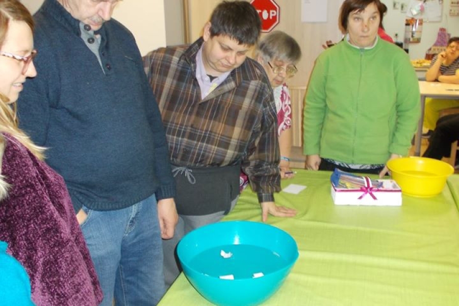 Uczestnicy przy stole podczas lania wosku przez klucz