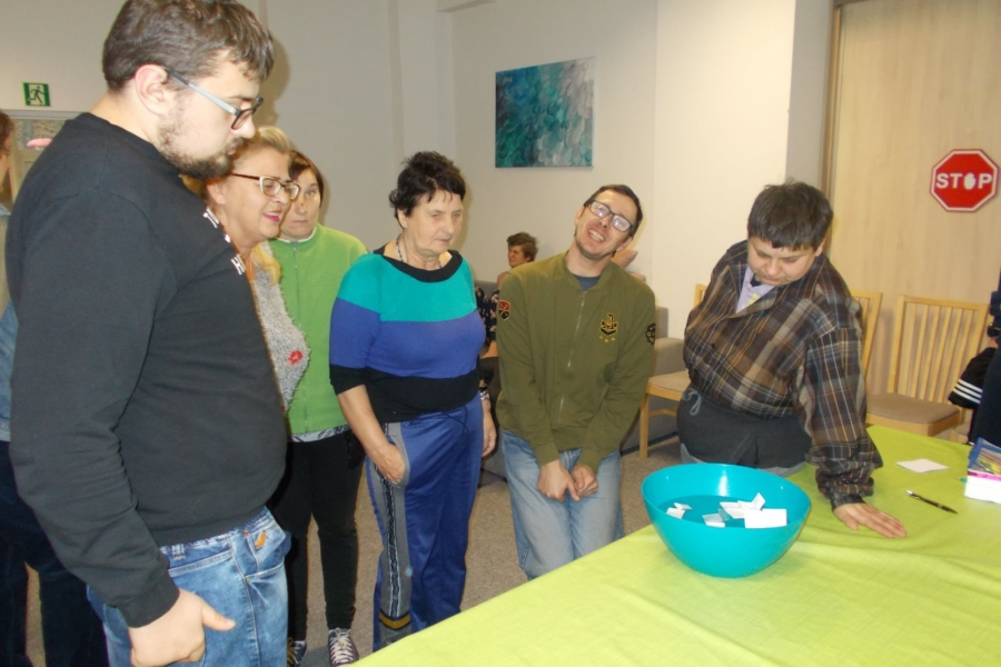 Uczestnicy przy stole podczas lania wosku przez klucz