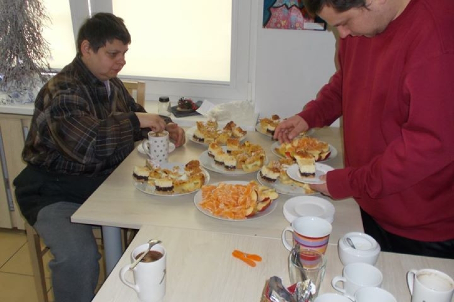 Uczestnicy podczas poczęstunku przy stole