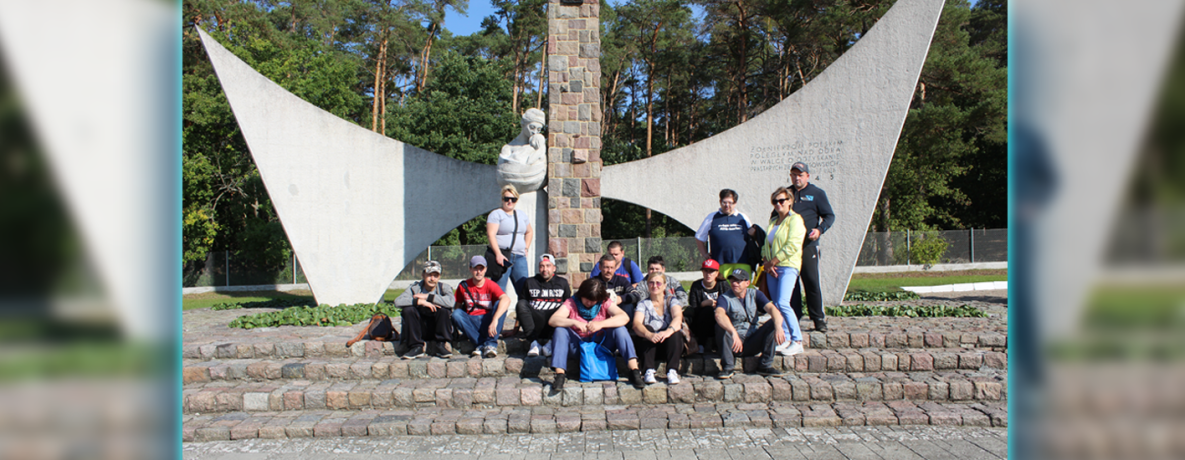 Grupa uczestników na tle pomnika poległym Żołnierzom Polskim 