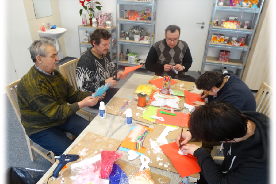 Grupa uczestników wykonująca prace rękodzielnicze z papieru w ramach pracowni rzemiosł różnych 