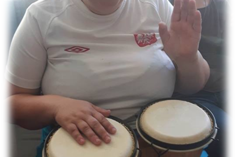 Uczestniczka gra na bongos. 