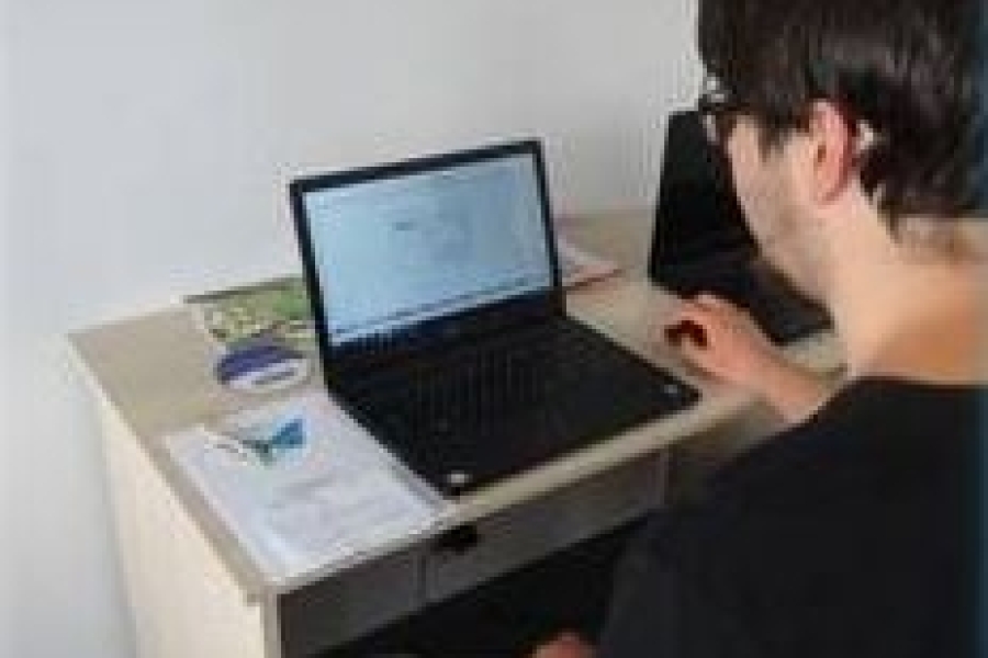 Uczestnik w trakcie przeglądania prasy internetowej na laptopie