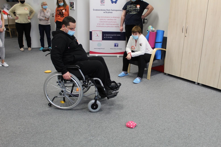 Uczestnik wykonujący slalom na wózku inwalidzkim.