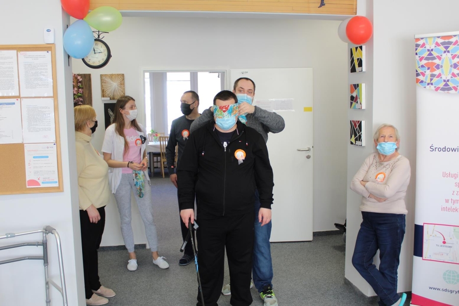 Terapeuta zasłaniający chustą oczy Uczestnika.