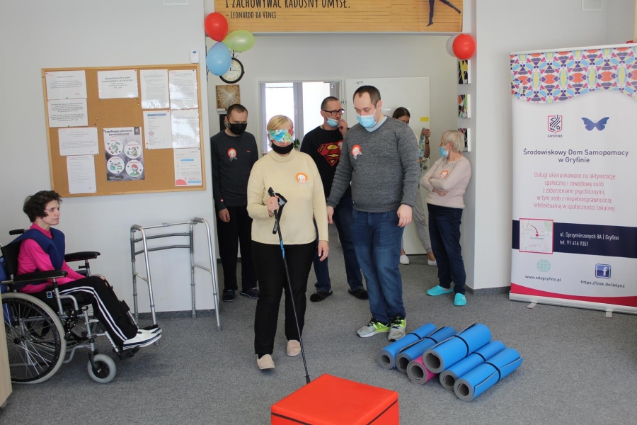 Uczestniczka w asyście terapeuty pokonująca tor przeszkód z zasłoniętymi oczami.