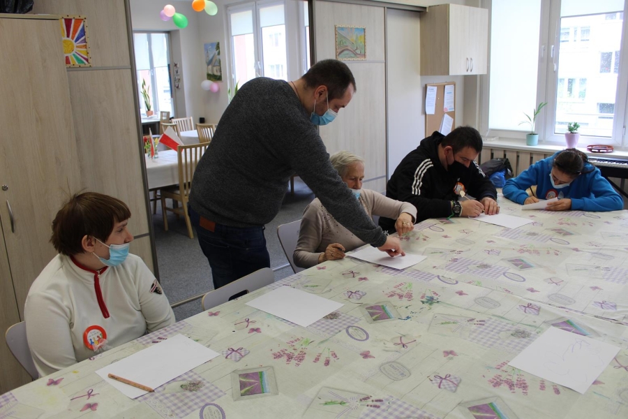 Uczestnicy w asyście Terapeuty wykonujący pracę plastyczną. 