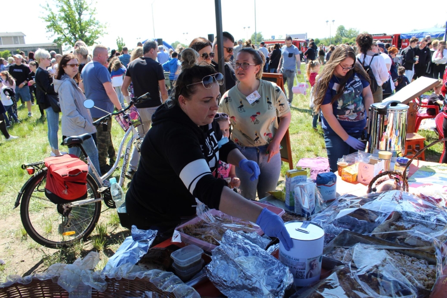 25 Opiekun medyczny wrzucający datek do puszki przy stoisku na tle tłumu