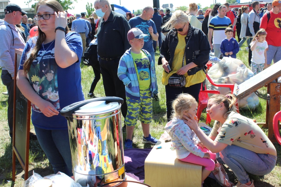 29 Psycholog malująca twarz dziewczynki na tle tłumu