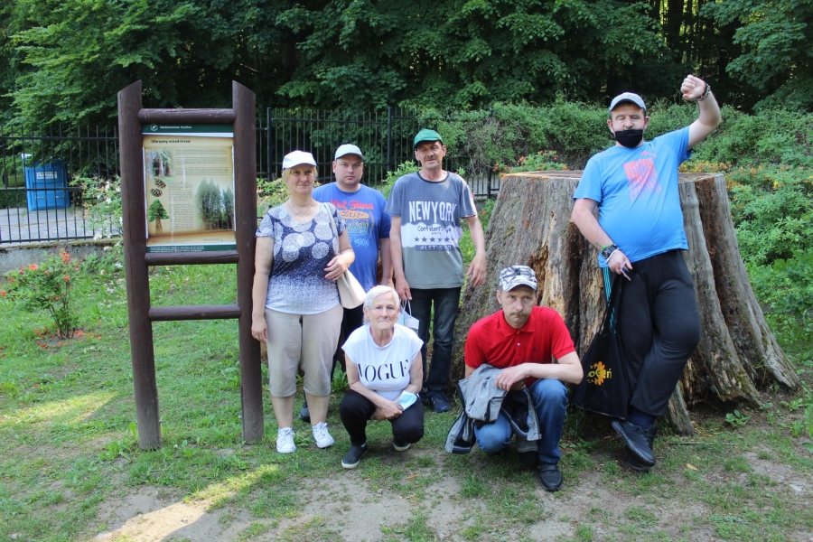 1 Uczestnicy pozujący do zdjęcia na tle ściętego drzewa.