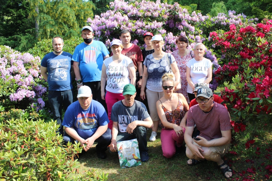 2 Grupa Uczestników na tle kolorowych kwiatów.