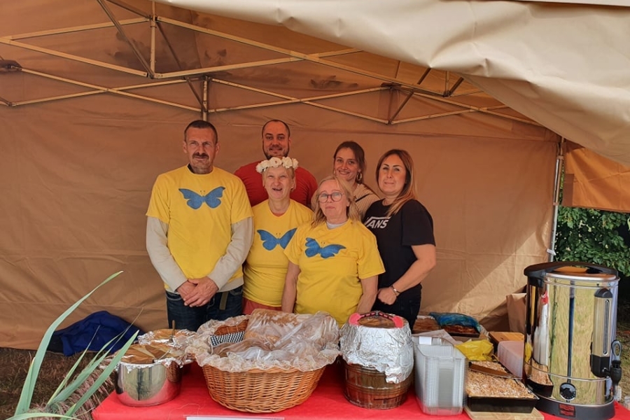 3. Uczestnicy z terapeutami pozujący do zdjęcia na tle stoiska