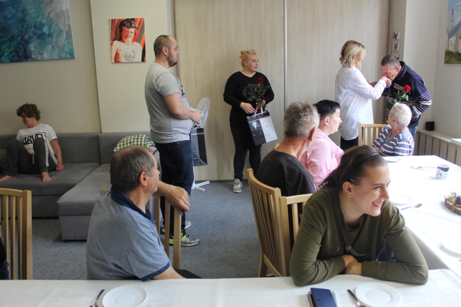 6. Uczestnik całujący dłoń Kierownik ŚDS w Gryfinie na tle grupy.