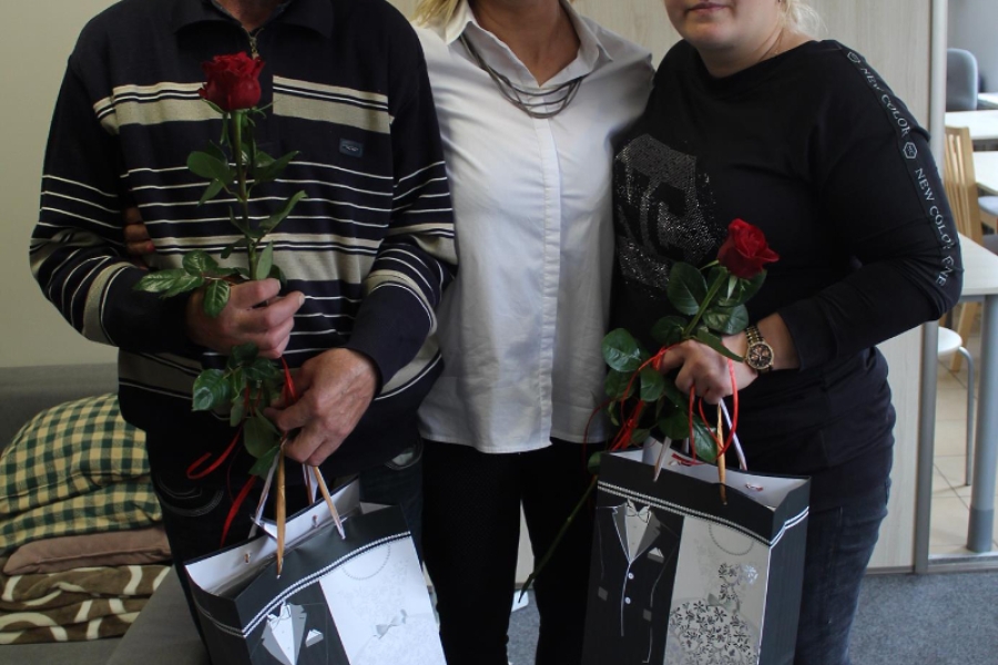 9. Kierownik ŚDS w Gryfinie z dwójka Uczestników trzymających  upominki.